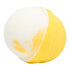 A bath bomb with a yellow bottom and white top, with yellow speckles on the white surface.